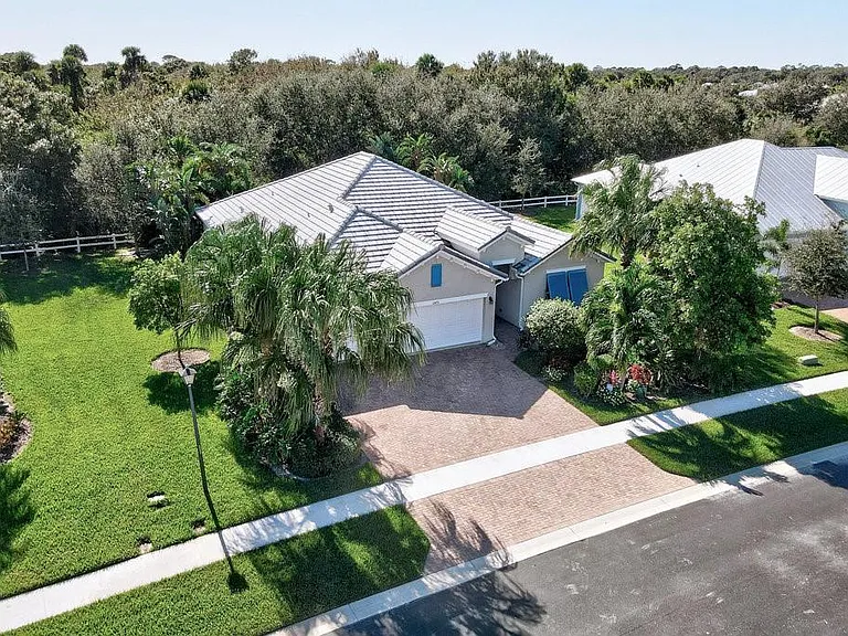 Port St. Lucie home with screened lanai and garden view
