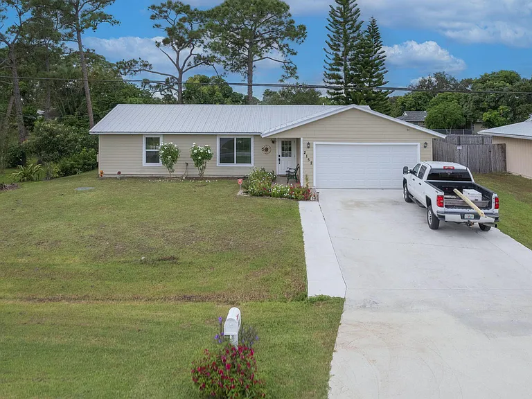 Port St. Lucie home with long driveway and two-car garage